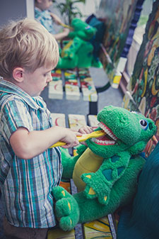Child brushing stuffed animals teeth - Pediatric Dentist serving Lincoln Park and Hyde Park, IL