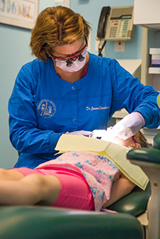 Hygienist looking at patients teeth - Pediatric Dentist serving Logan Square and Hyde Park, IL